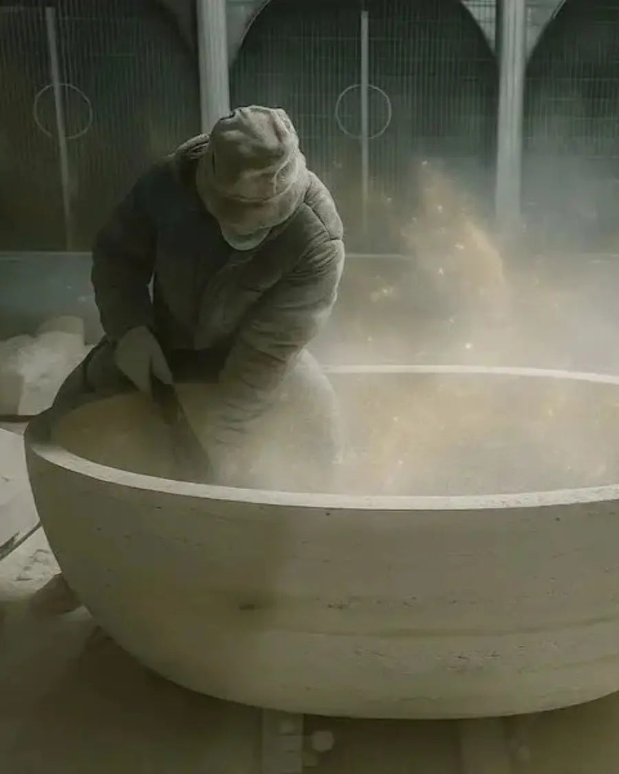 Person in a large white container with dust or powder, possibly in a laboratory or industrial setting.